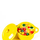 The Yellow Mini Cereal Crockpot Candle features colorful, round cereal pieces in milk inside a yellow pot with a matching lid, resembling a playful, fruity scented candle against a white background.