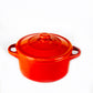A Red Mini Cereal Crockpot Candle with a lid and two side handles sits on a plain white background.