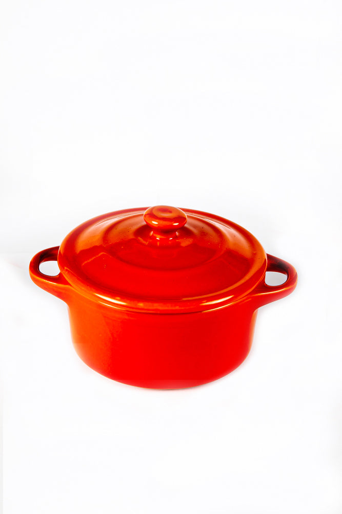 A Red Mini Cereal Crockpot Candle with a lid and two side handles sits on a plain white background.