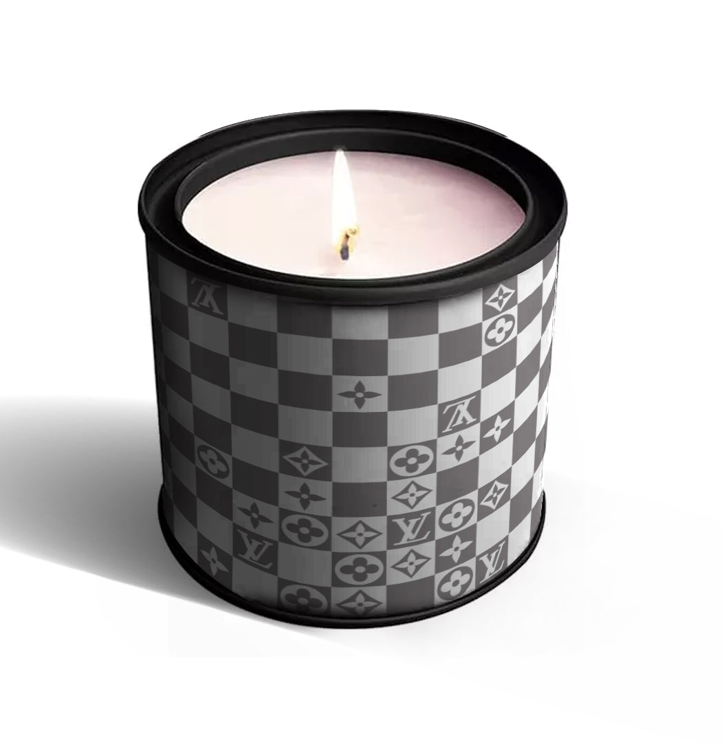 The Checkered Designer Tin Candle features a lit cotton wick and natural soy wax in a round tin with black, gray, and white luxury brand-style checkered patterns.