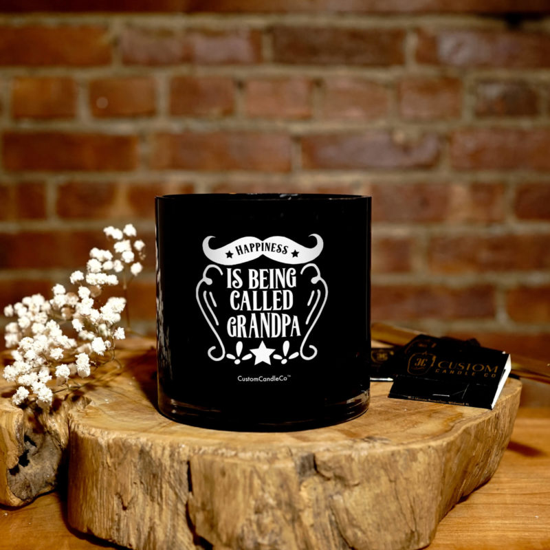 Black tumbler with silver top with a quote that says Happiness is being called Grandpa on a wooden background