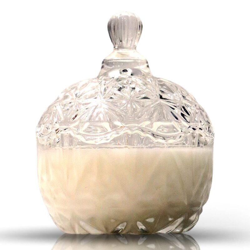 A Clear Glass Sugar Dish Candle with a lid is placed on a white surface.