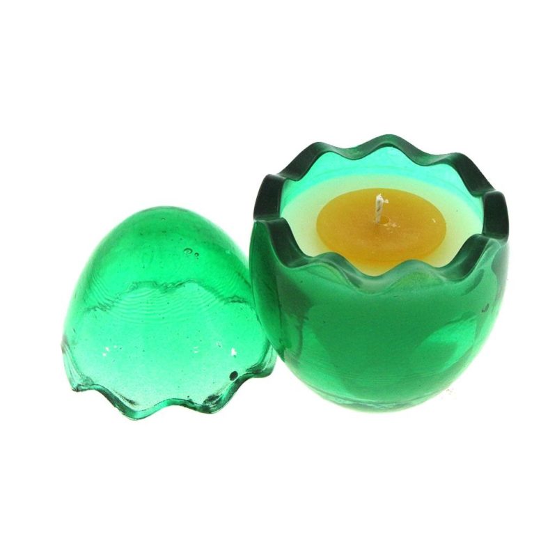 A green glass Easter egg candle holder with white wax and yellow wax (yolk) candle on top.