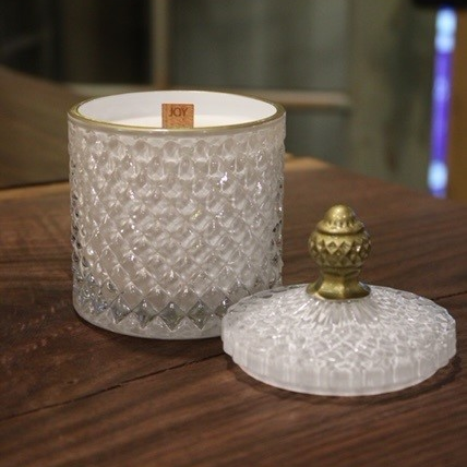 Elegant White Crystal Scented Candle with a gold lid on a wooden table.