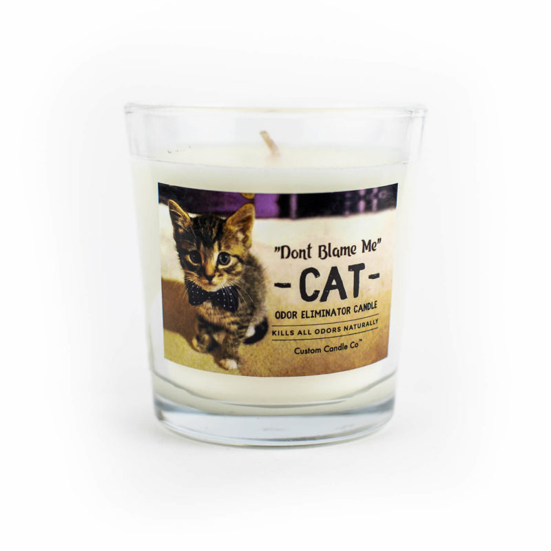 A "Don't Blame Me" Cat Candle Odor Eliminator with a picture of a cat on it.