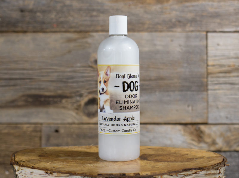 A bottle of Dog Shampoo - Lavender Apple 16oz sitting on top of a wooden table.