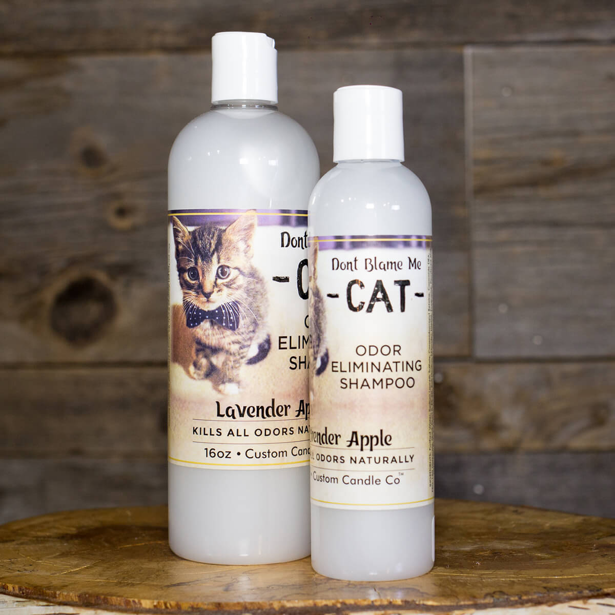 A bottle of Cat Shampoo - Lavender Apple 8oz and 16 oz on a wooden table.