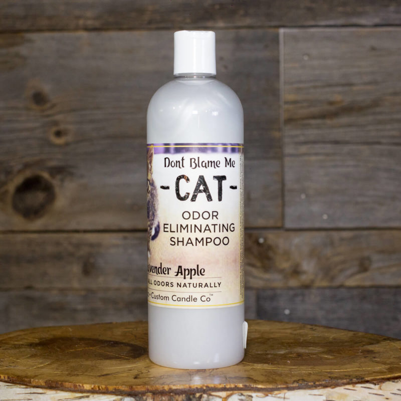 A bottle of Cat Shampoo - Lavender Apple 16oz on a wooden table.