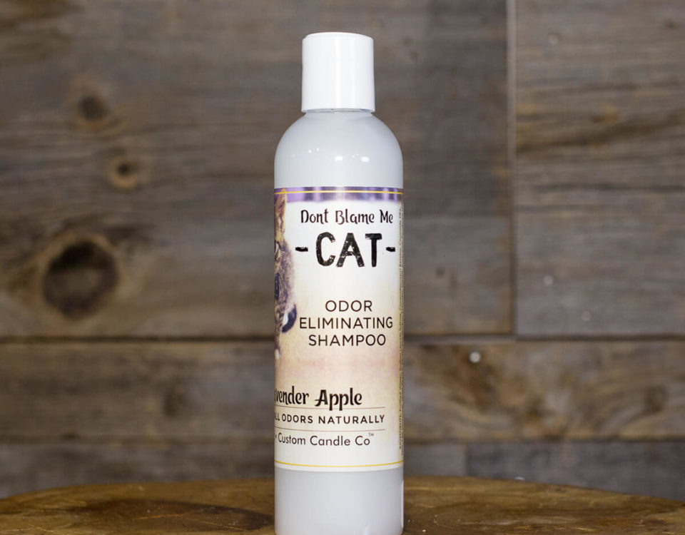 A bottle of Cat Shampoo - Lavender Apple 8oz sitting on a wooden table.