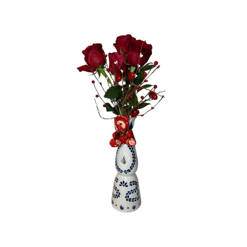 A vase with red roses in it.
