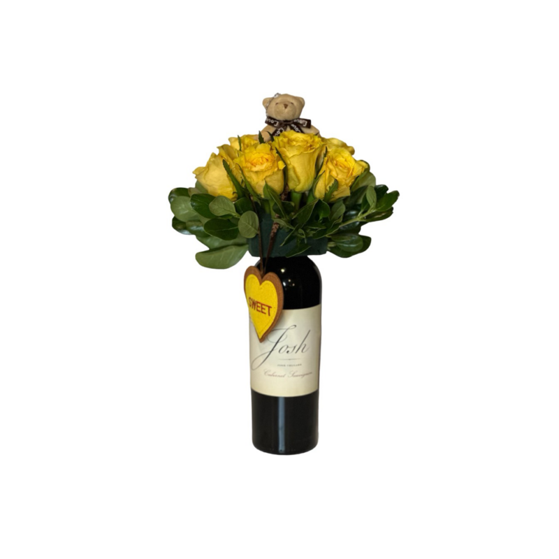 A Wine and Flower of yellow roses in a wine bottle.